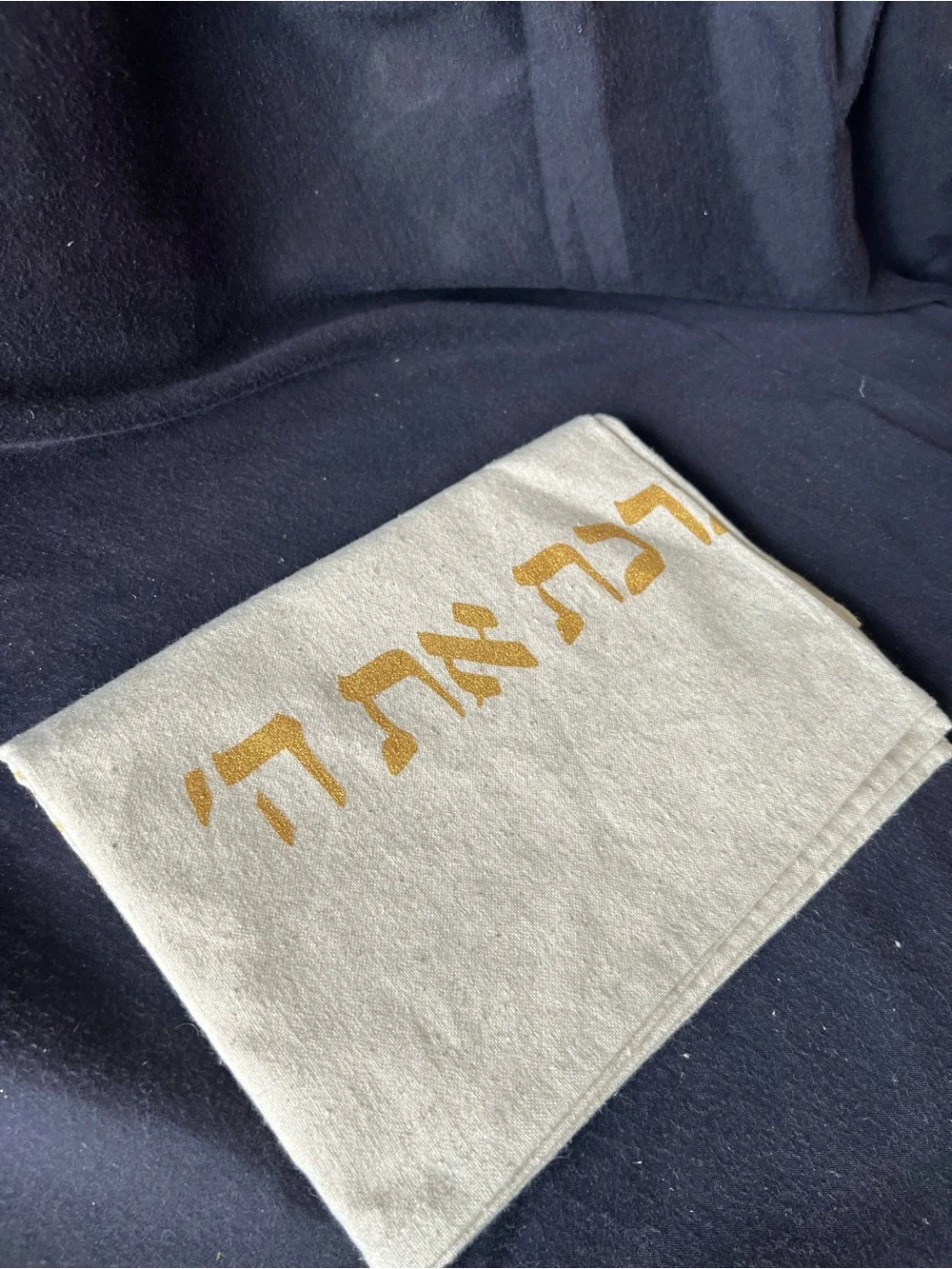 Gold and cream Shabbat tablecloth with gold Hebrew text and illustrations